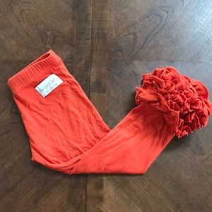 Pumpkin/burnt orange colored ruffle pants.